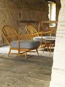 Sessel im Fiftiesstil auf altem Dielenboden im rustikalen Ambiente