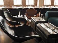 Stühle und alte Truhen als Beistelltische in einem Clubraum