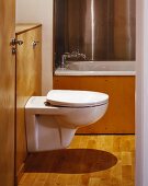 Toilette in Bad mit Holzverkleidung & Parkettboden