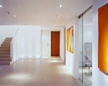 Grosszügiger moderner Vorraum mit Treppenaufgang und offenstehender Glasschiebetür
