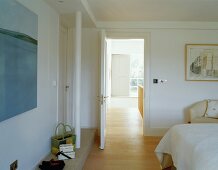 Modernes Schlafzimmer mit Blick durch offenstehende Tür ins Treppenhaus