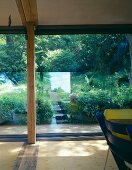 Wohnraum mit raumhohem Terrassenfenster und Blick in Garten