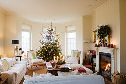 Helle Sofagarnitur in traditionellem Wohnraum und Weihnachtsbaum im Erker
