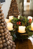 Christmas wreath with white candles and ornamental fir trees made of wooden balls