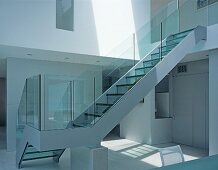 Glass staircase leading from dining room to upper storey
