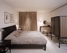 Schlafzimmer mit Doppelbett und Umkleide und Paravent