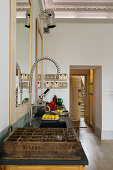 Kitchen countertop with designer faucet and vintage glass crate in a renovated old building