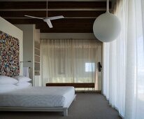 Schlafzimmer mit Deckenventilator und Mosaikbild an der Wand