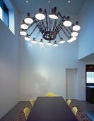 Retro pendant lamp with cantilever arms above dining table in minimalist room