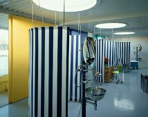 Cool, maritime atmosphere in unusual bathroom with bullseye windows in ceiling and blue and white striped screens