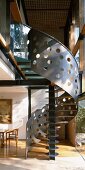Gallery in living space - sheet metal with irregular punched holes forms balustrade of modern spiral staircase