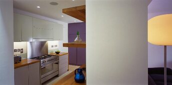 Open-plan kitchen with wooden shelves