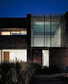 Entrance of contemporary house with slatted structure at dusk