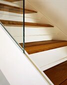 White metal staircase with wooden treads and glass balustrade