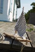 Small, home-made wooden boat with striped sail
