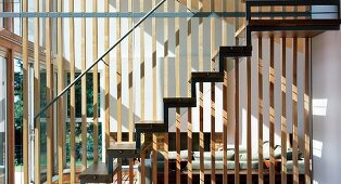 Holzgitter als Trennwand zwischen Wohnzimmer und Treppenaufgang