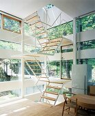 Leichte Treppenkonstruktion in einem Haus aus Glas- und Holzelementen