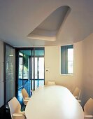 White dining table and chairs under suspended ceiling with cut-out