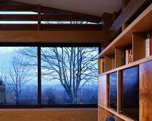 Ausschnitt eines Wohnraumes mit Panoramafenster und Blick auf herbstliche Landschaftsstimmung