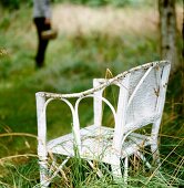 Weathered wicker chair in grass