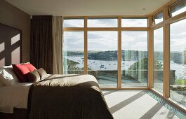 Schlafzimmer mit Glasfront und Blick auf den Fluss