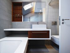 Massgefertigter Waschtisch und Spiegelschrank im grau gefliesten Designerbad