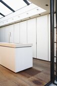 Moderner Spülenblock und viel Stauraum hinter grifflosen Türen in minimalistischer Küche