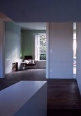 Vorraum mit breitem Durchgang und Blick in minimalistischen Wohnraum