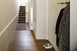 Coat rack in simple hallway with old floorboards