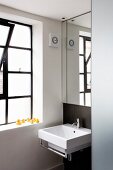 Mirror above designer washstand in niche with window