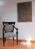 Baroque chair with upholstered back and seat next to modern floor lamp
