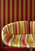 Striped patterns on elegant chair with fabric cover and wallpaper