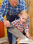 Grandfather and grandson sawing