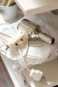 Retro-look hairdryer lying on white towels