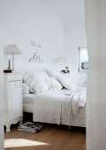 Romantisches Schlafzimmer in Weiß - Blick auf Bett mit weisser Spitzenbettwäsche