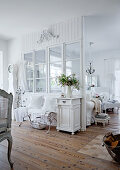 White-painted, wooden partition with glass panels and rustic wooden floor in country-style living-dining room