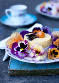 Cream tart on plate decorated with violas