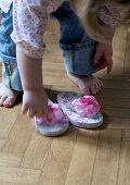Little girl putting on flip-flops