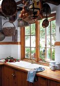 Rustikale Küche mit hängenden Kupfertöpfen und Kochutensilien