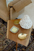 Various dishes on wooden side table in simple 50s style and partial view of sofa armrest
