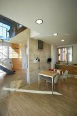 Minimalistische Küche mit Teilverglasung und Blick ins lichtdurchflutete Treppenhaus