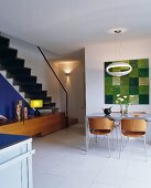 Modern, retro-style, wooden shell chairs at dining table in open-plan interior with staircase