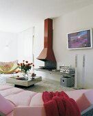 View across pink sofa of open fireplace with red chimney breast in modern living room