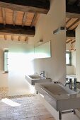 Designer bathroom in renovated country house - two sinks with mirrors and glass shower partition