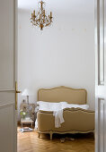 Blick durch offene Tür auf Französisches Corbeille-Bett im Schlafzimmer einer Altbauwohnung