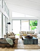 Helle Polstergarnitur und Tisch aus Metall in modernem Wohnzimmer in zeitgenössischem Glas-Stahl Anbau