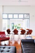 Stühle mit Holzschale im Retrostil vor modernem Esstisch in offenem Wohnraum