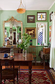 Dark wood dining table and chairs in Art Nouveau living room with green-painted walls
