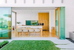 Glass-fronted dining room in modern, architect-designed house with access to manicured garden