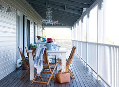 Simple table and chairs on the veranda of a wooden country home
